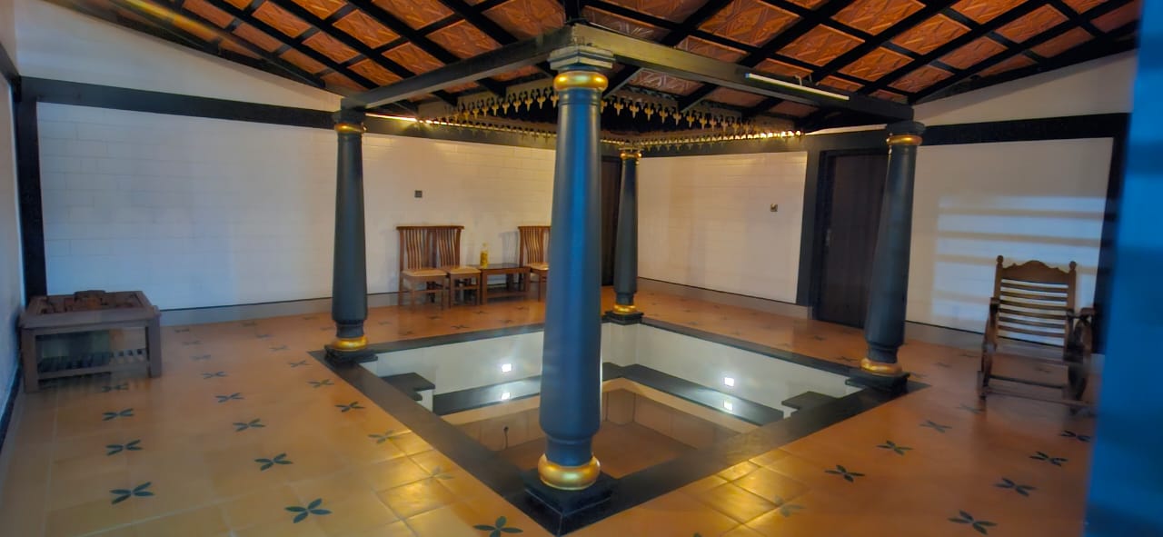 A rectangular pool with gold pillars and a detailed tile roof is at Aqua Terra Villas - Belur, Sakleshpur