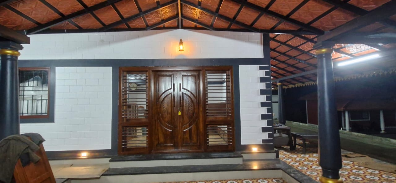 A house with a wooden door and metal-grilled windows, at Aqua Terra Villas - Belur, Sakleshpur