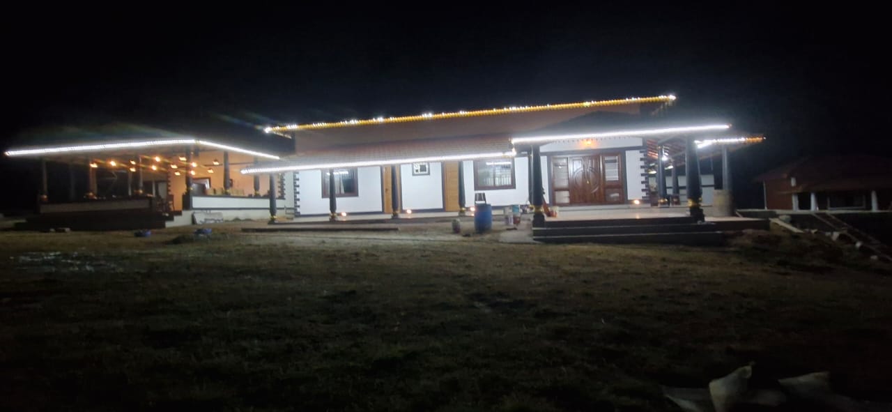 Two-story house with brown roof and white string lights at Aqua Terra Villas - Belur, Sakleshpur