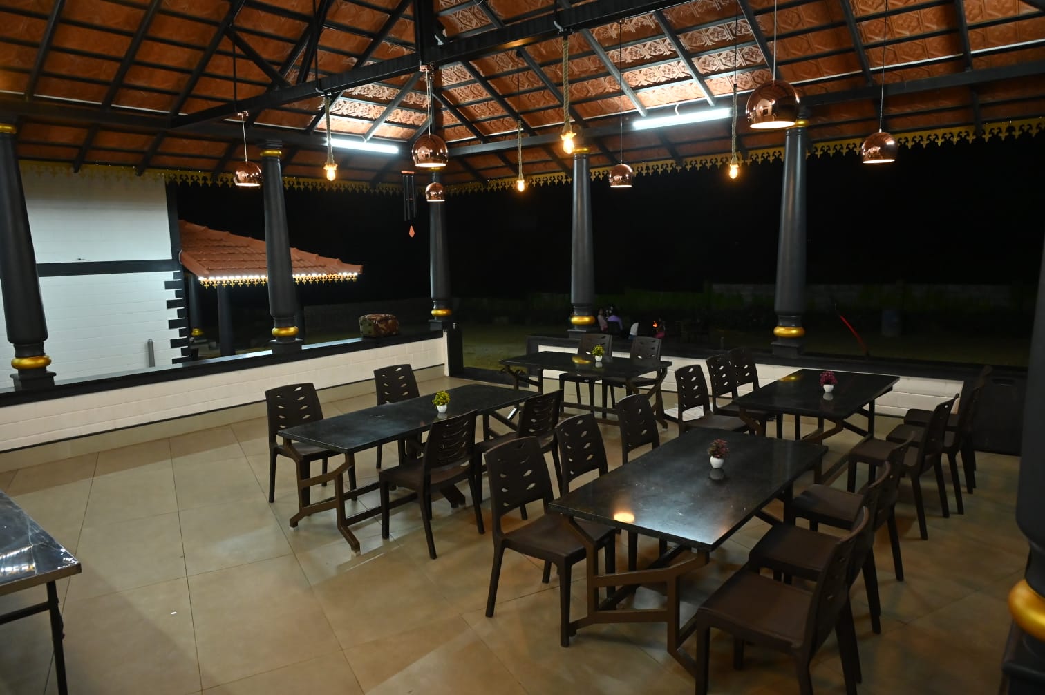 Serene restaurant with wooden roof and black pillars at Aqua Terra Villas - Belur, Sakleshpur