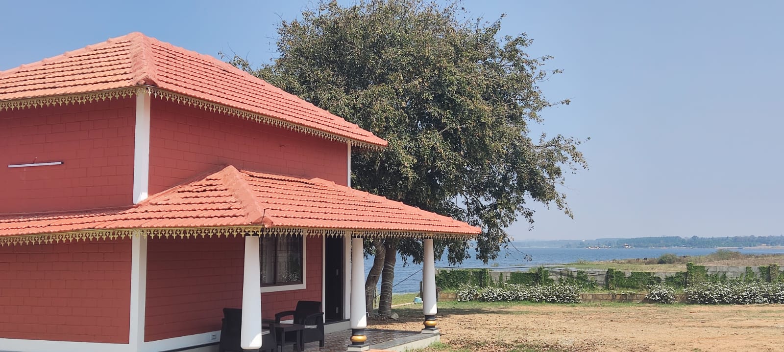 A red house with a yellow trim and terracotta roof at Aqua Terra Villas - Belur, Sakleshpur