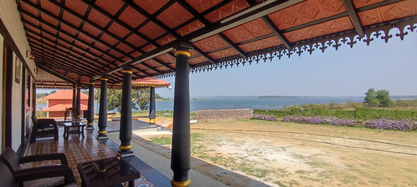 A long porch with red tiled roof and black metal accents at Aqua Terra Villas - Belur, Sakleshpur