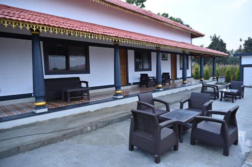 Two-story building with red tiled roof and dark blue pillars at Aqua Terra Villas - Belur, Sakleshpur