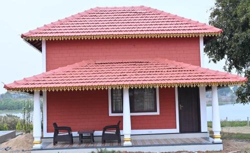 A two-story red house near a lake at Aqua Terra Villas - Belur, Sakleshpur