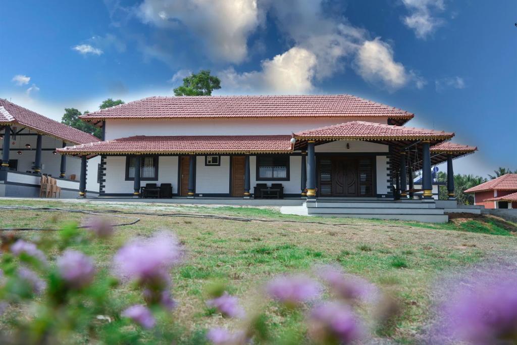 Two-story house with a white exterior and red roof at Aqua Terra Villas - Belur, Sakleshpur