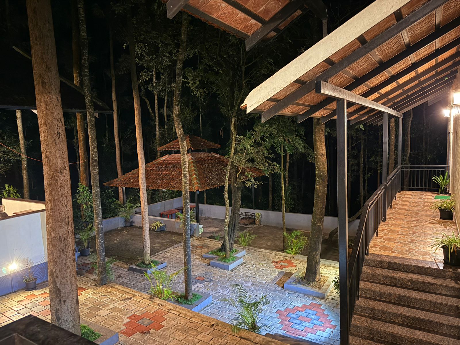 A garden with a metal-roofed structure at Janani Ecostay - Chikmagalur
